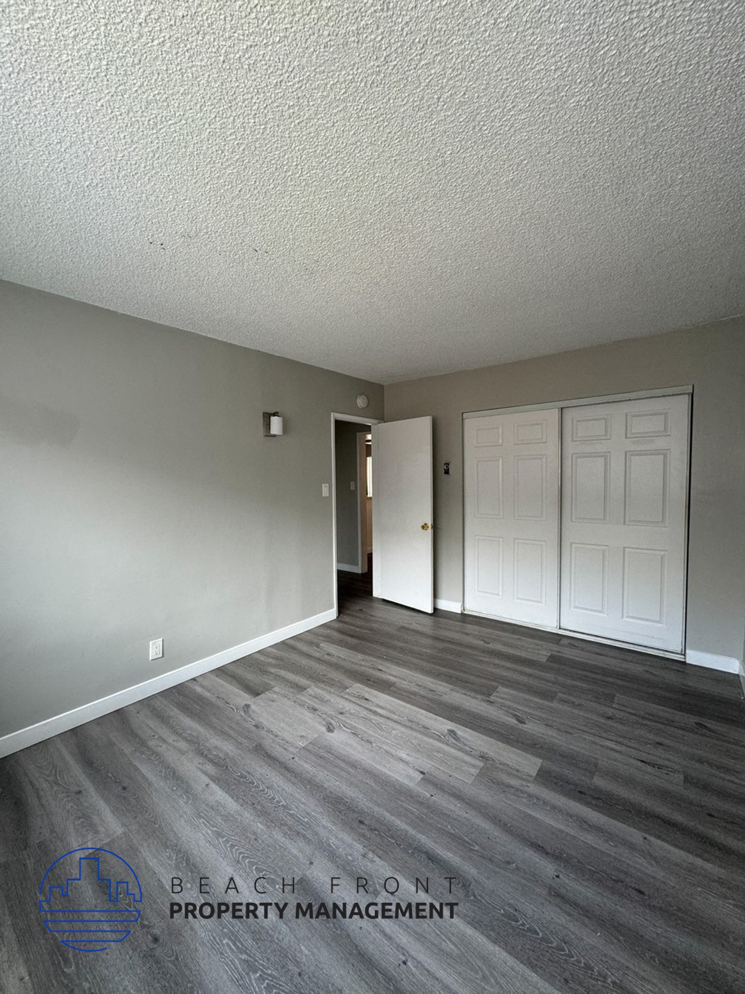 an empty living room with wood floors and a white door